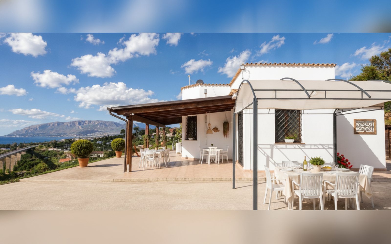 Veranda coperta con tavolo da pranzo e vista sulle colline