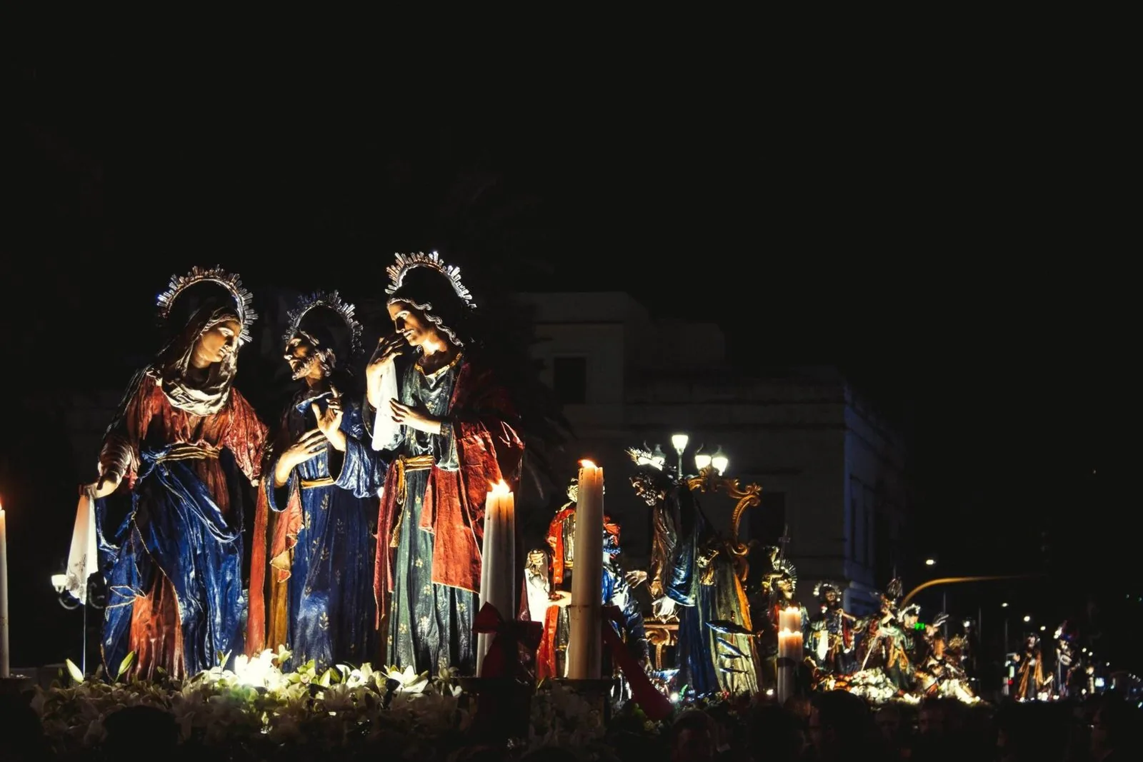 I gruppi scultorei dei Misteri di Trapani illuminati dalle candele durante la processione notturna