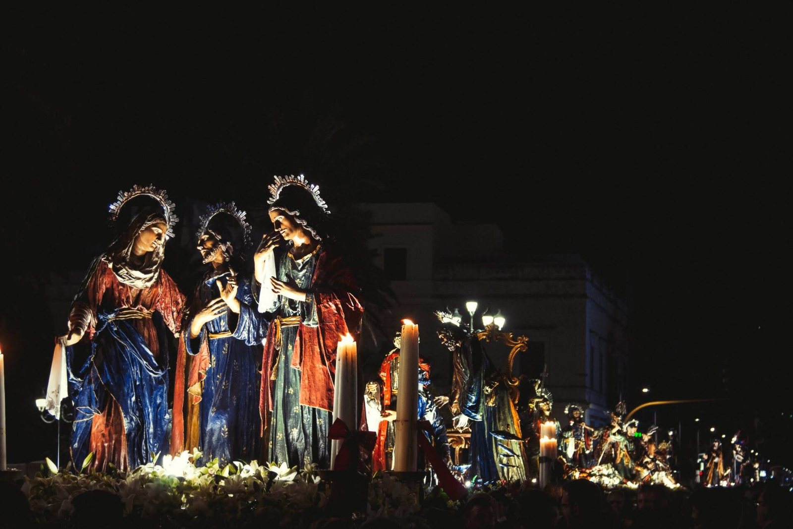 I gruppi scultorei dei Misteri di Trapani illuminati dalle candele durante la processione notturna